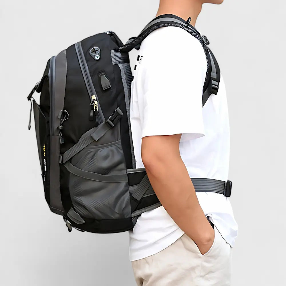 Sac à dos de voyage 40L noir porté sur le dos d’un homme