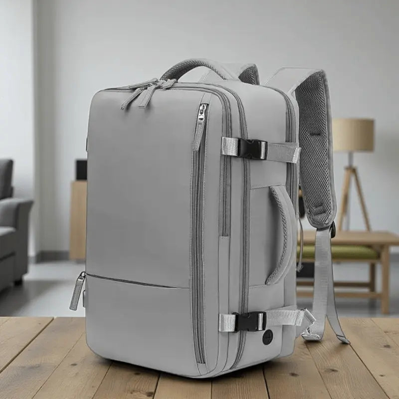 Vue avant du sac à dos de voyage mixte gris, design structuré et minimaliste, adapté aux formats cabine