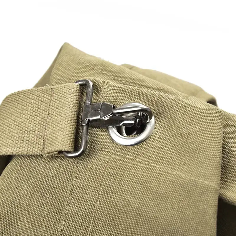 Détail de l’attache métallique du sac à dos de voyage en toile robuste kaki