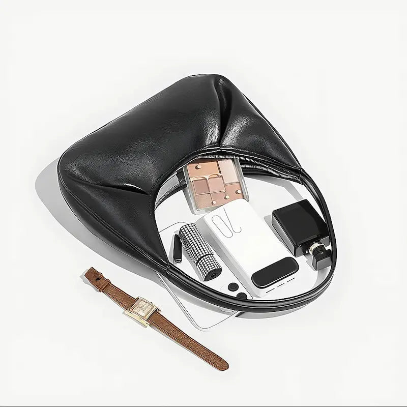 Sac à main croissant noir PU brillant avec contenu visible dans le compartiment principal