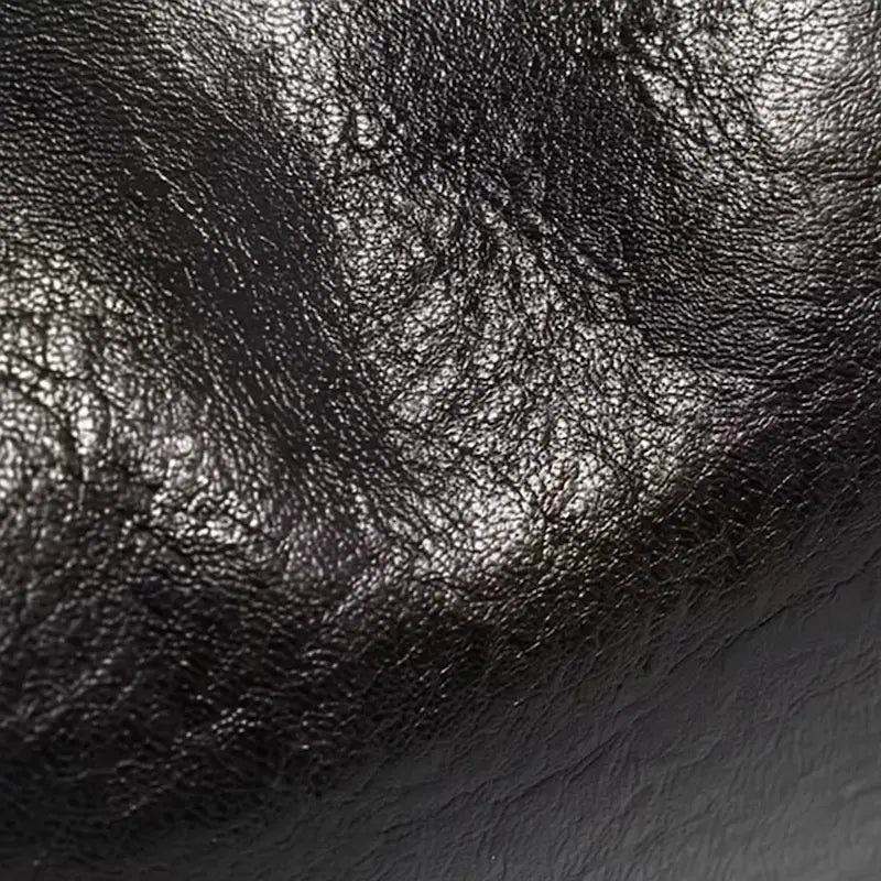 Zoom sur la texture en cuir PU brillant du sac à main croissant noir