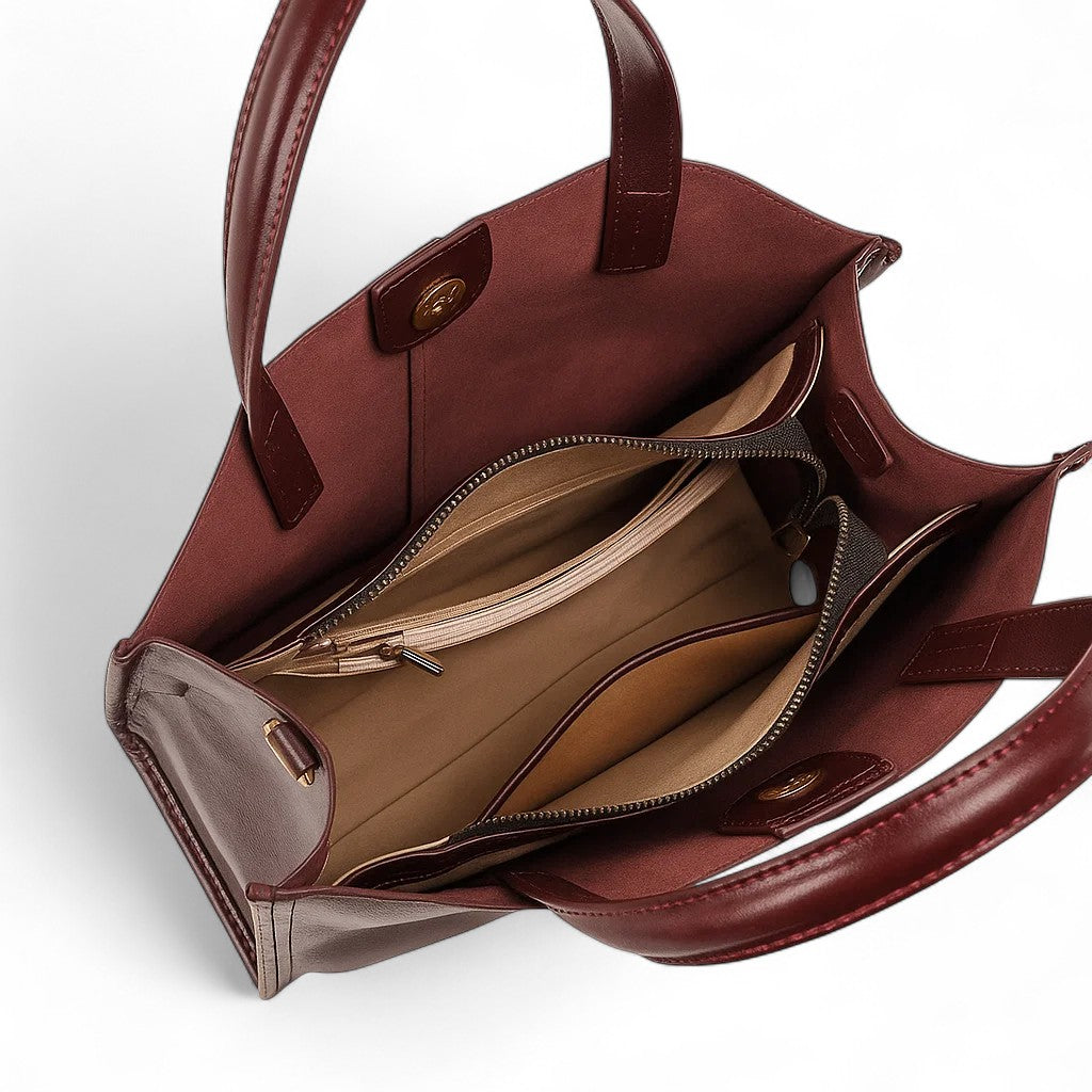 Vue intérieure d’un sac à main marron en cuir montrant les poches zippées et compartiments.