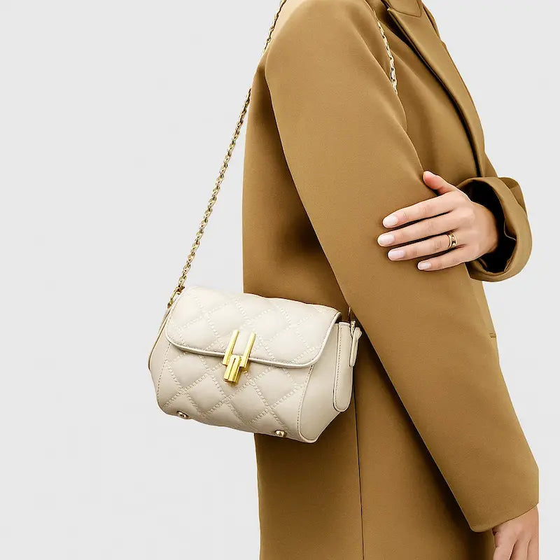 Sac à main matelassé beige porté à l’épaule avec chaîne dorée