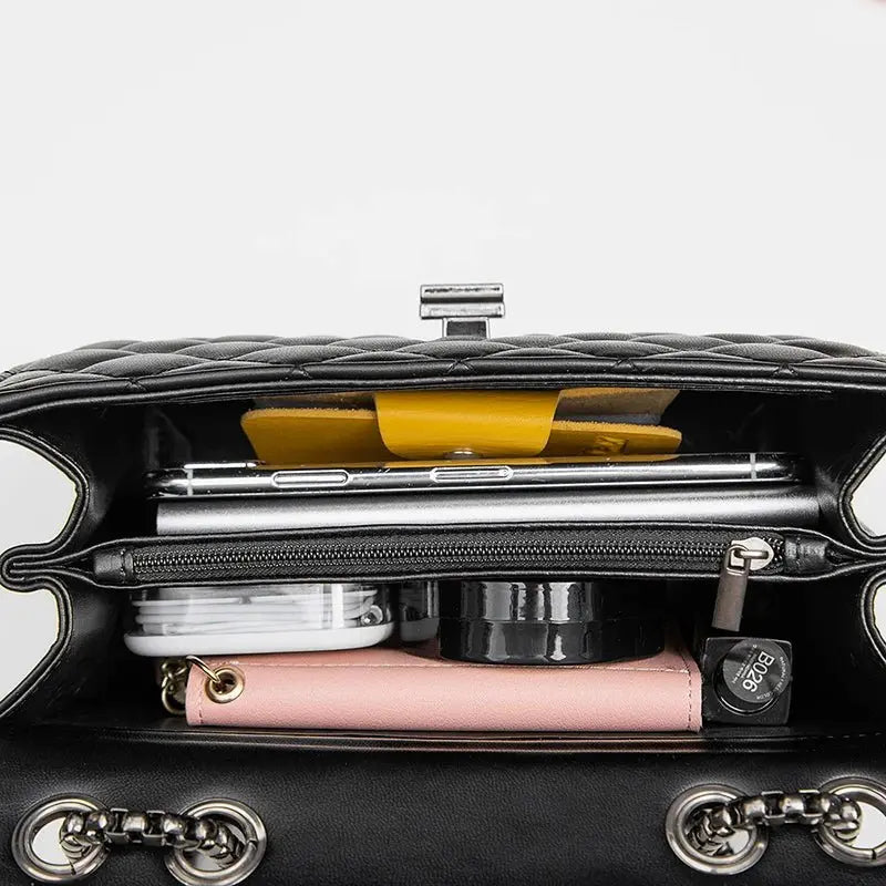 Intérieur du sac à main matelassé noir rempli avec accessoires