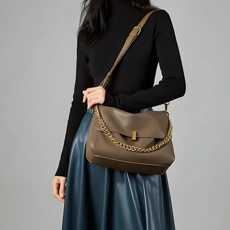 Sac à rabat souple en cuir marron porté à l’épaule avec chaîne dorée