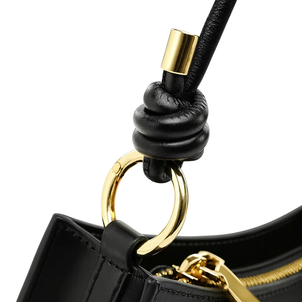 Détail de l’anneau doré du sac baguette en cuir noir
