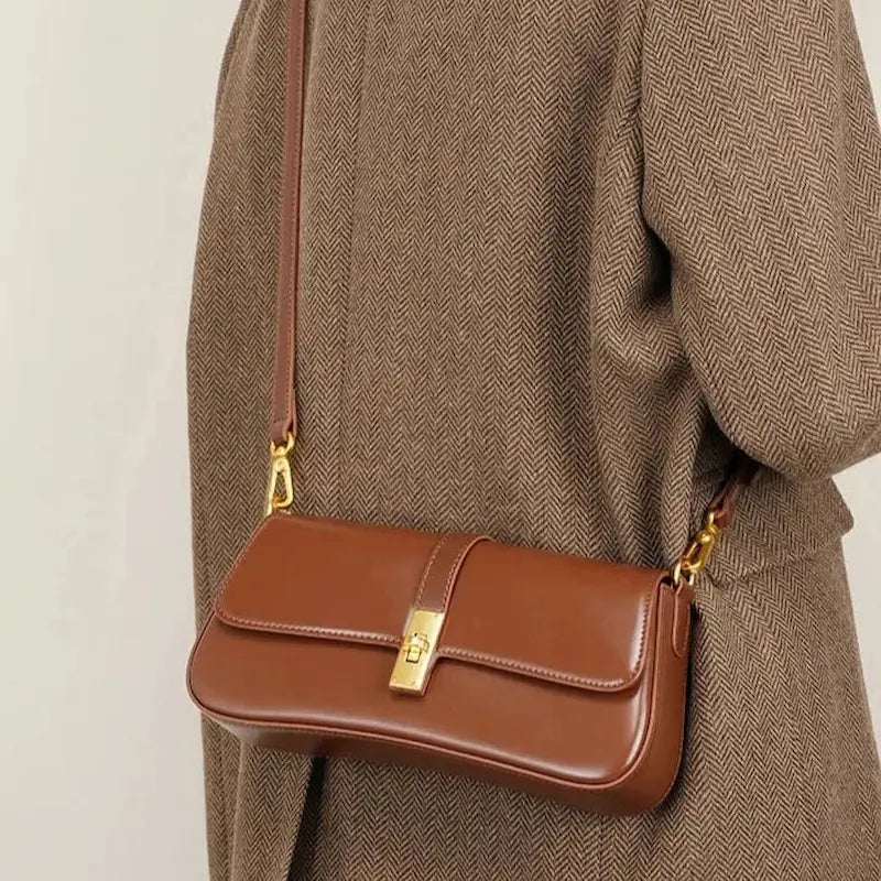 Sac baguette en cuir véritable marron porté à l’épaule avec bandoulière fine