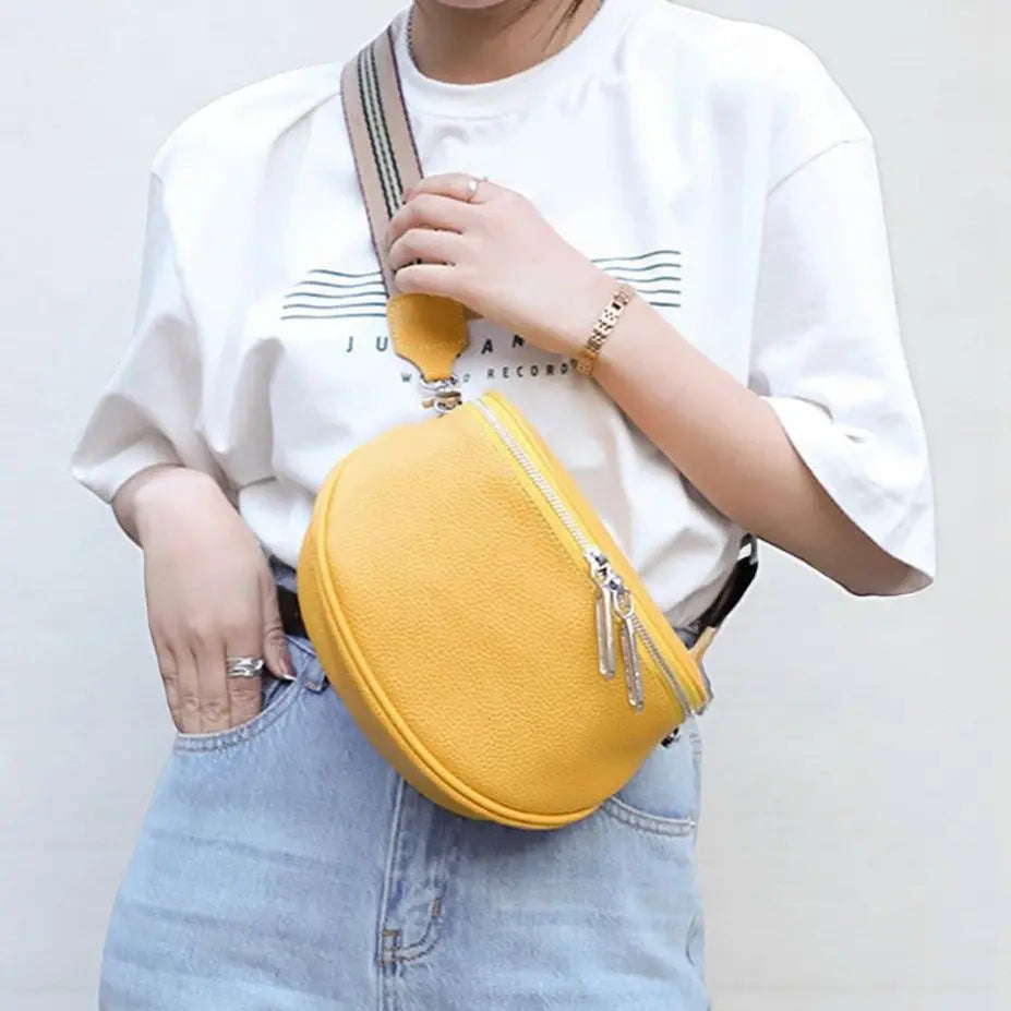 Sac banane femme en cuir véritable jaune porté à l’épaule avec fermeture zip double.