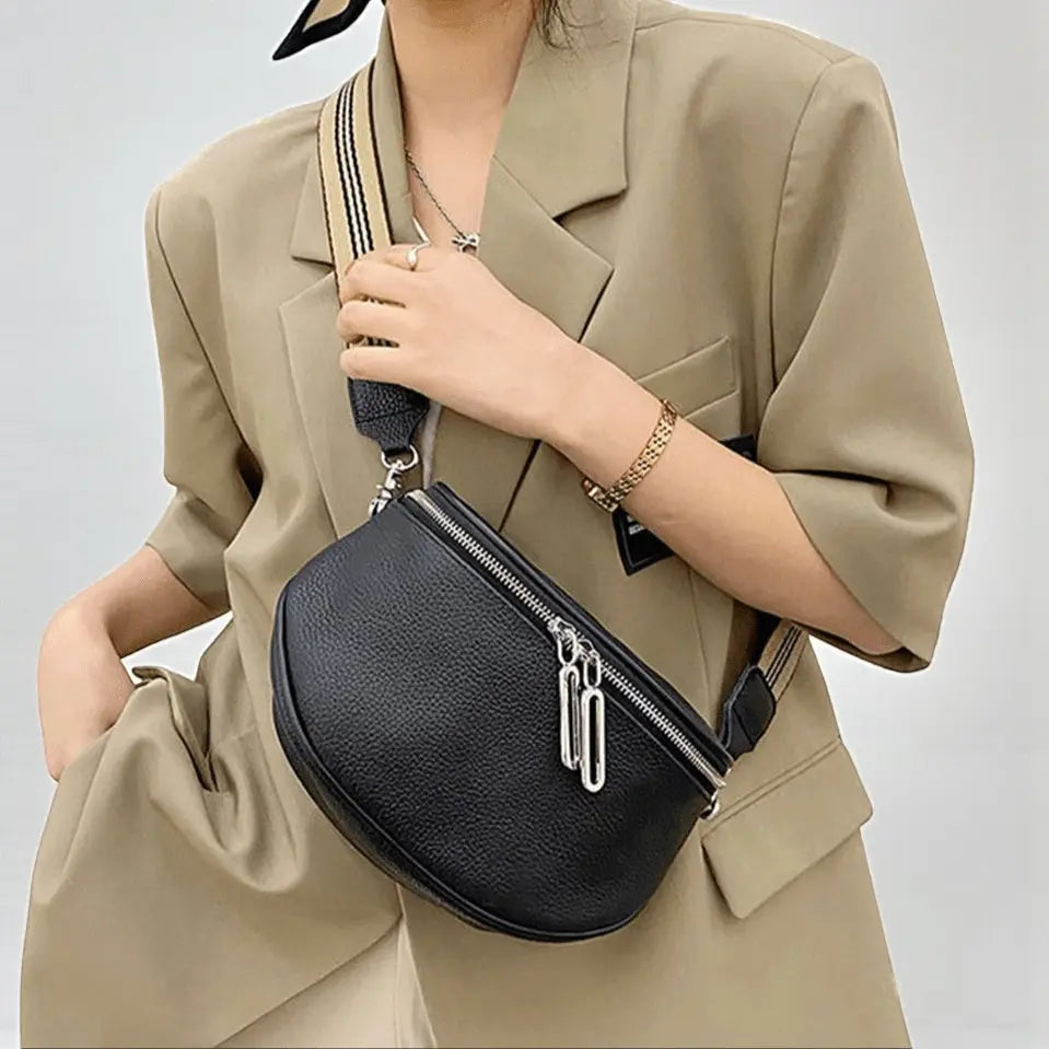 Sac banane femme en cuir véritable noir porté en bandoulière avec zip double.