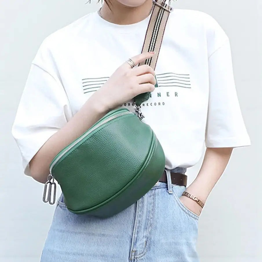Sac banane femme en cuir véritable vert porté en travers avec zip double et bandoulière réglable.