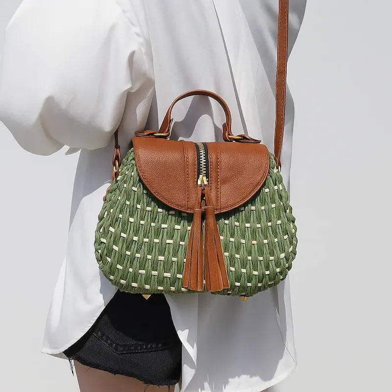 Sac bohème en paille tressée porté à l’épaule avec bandoulière et rabat en cuir