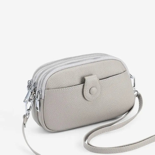 Sac bandoulière en cuir véritable beige porté à l’épaule pour femme