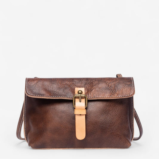 Petit sac bandoulière en cuir couleur café avec rabat rétro et boucle beige sur le devant.