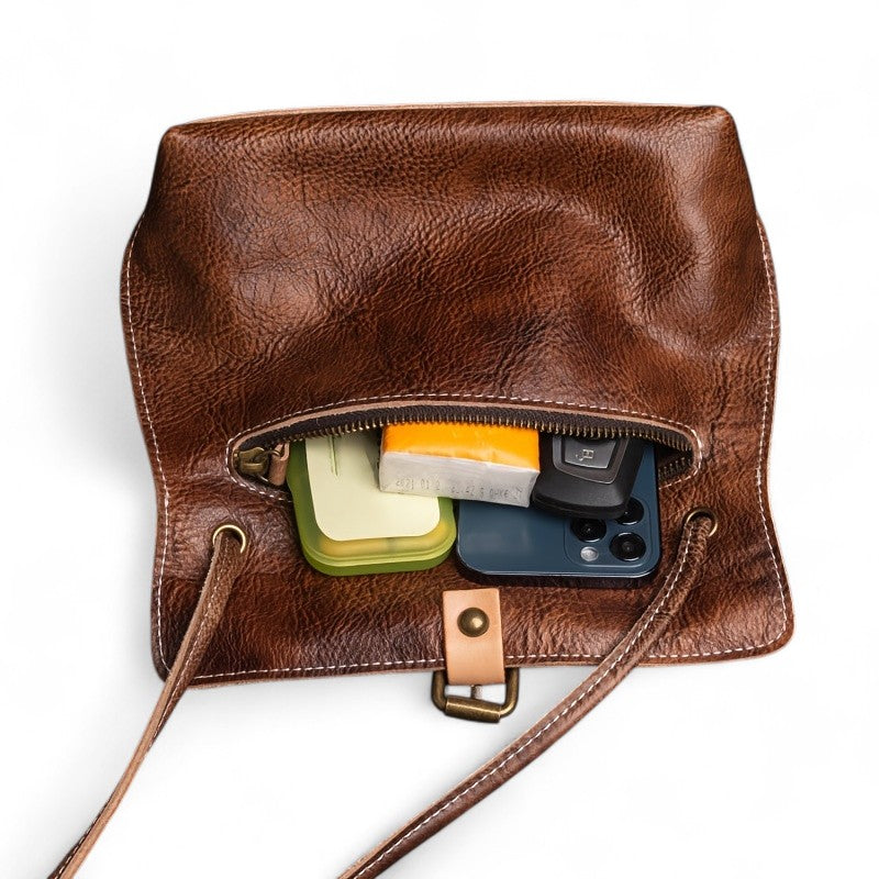 Vue intérieure du sac bandoulière en cuir café avec rangements pour téléphone et accessoires.