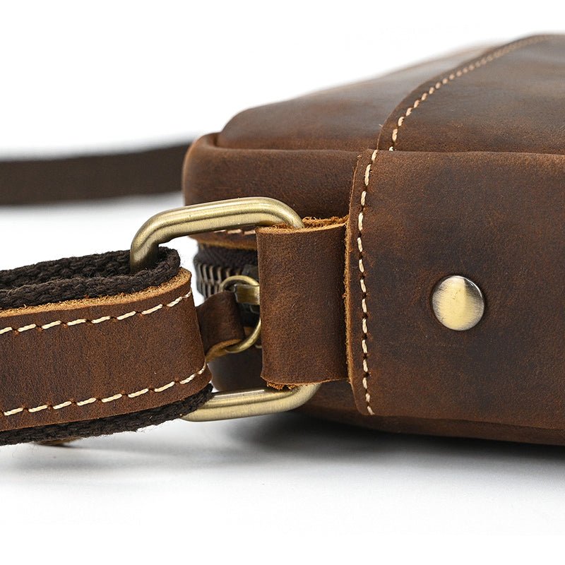 Zoom sur l’anneau métallique du sac bandoulière en cuir de vachette marron