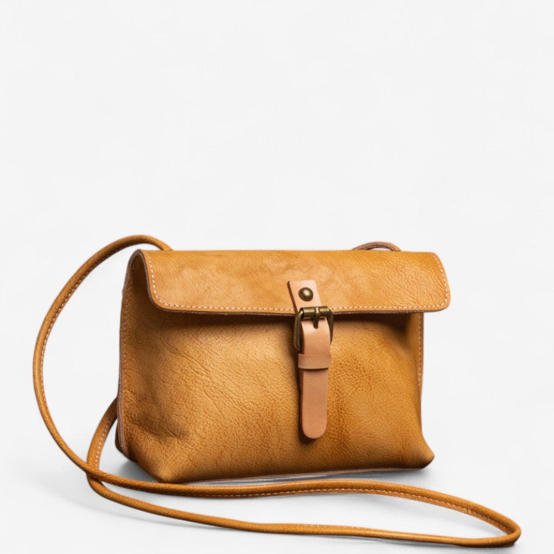 Vue de face du sac bandoulière en cuir jaune avec rabat à boucle beige et bandoulière fine assortie.