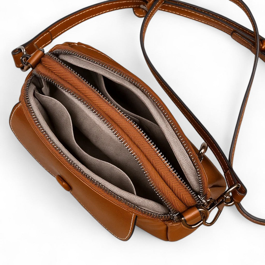 Vue intérieure du sac bandoulière marron foncé montrant les deux compartiments et la doublure beige.