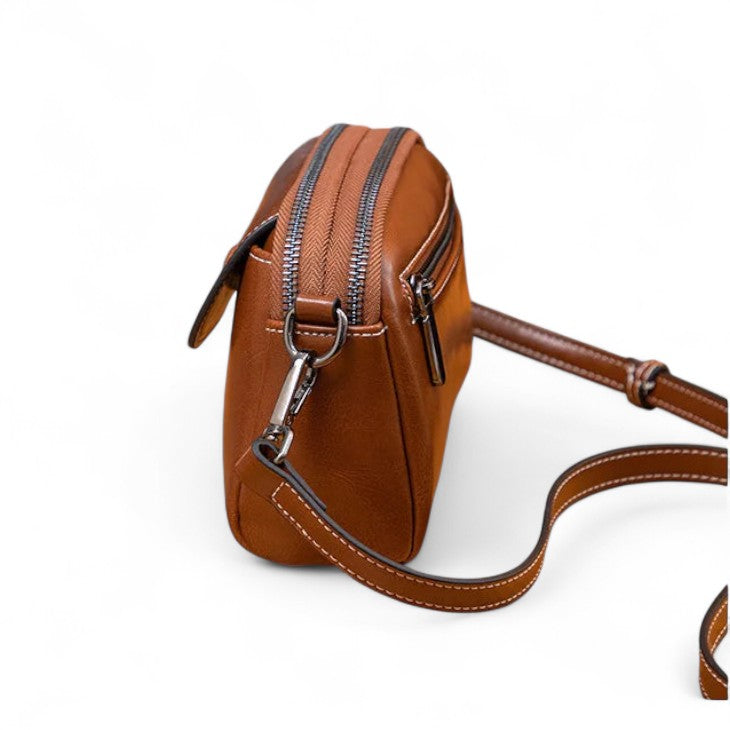 Vue latérale du sac bandoulière marron foncé mettant en avant sa profondeur de 6,5 cm.