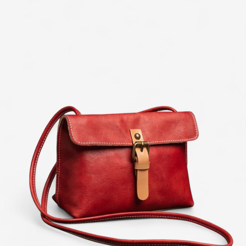 Vue de face du sac bandoulière en cuir rouge avec rabat et boucle beige.