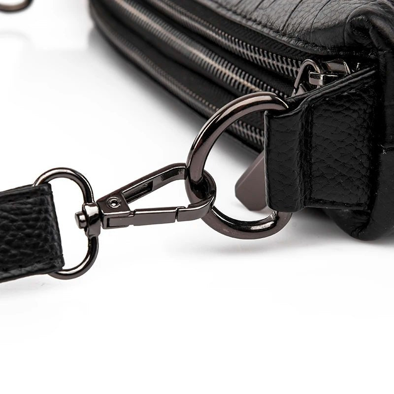 Détail de l’attache métallique du sac bandoulière en cuir noir croco