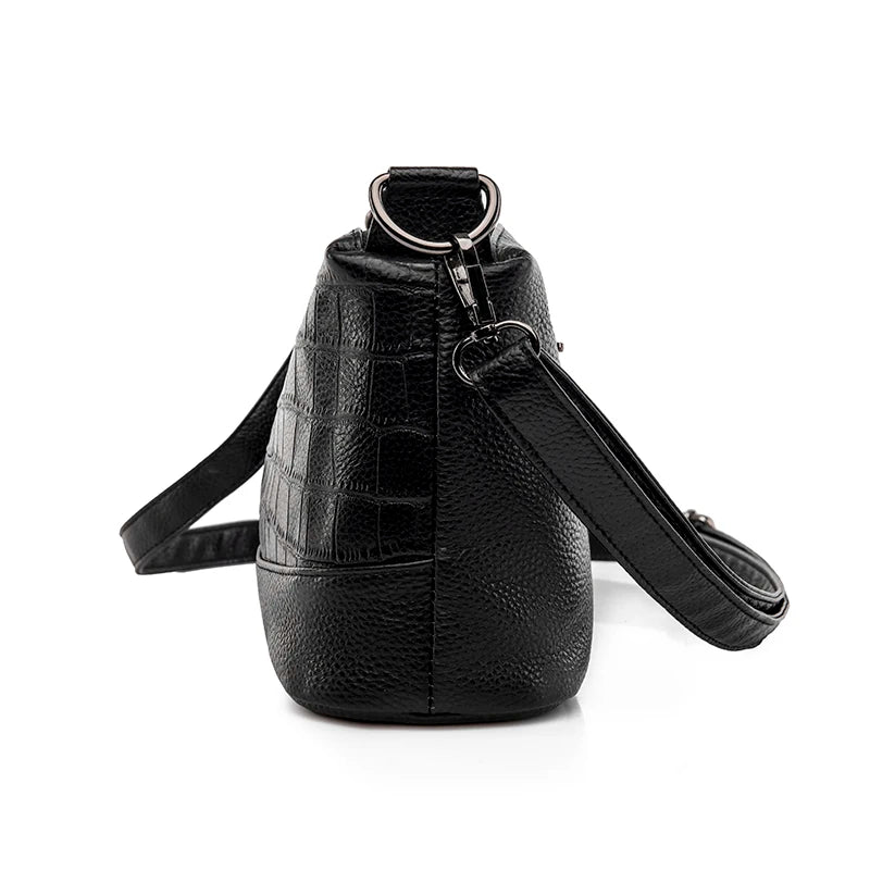 Vue de profil du sac bandoulière cuir noir croco avec bandoulière ajustable