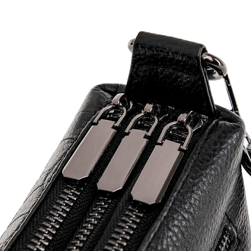 Trois fermetures éclairs robustes sur sac bandoulière cuir noir façon croco