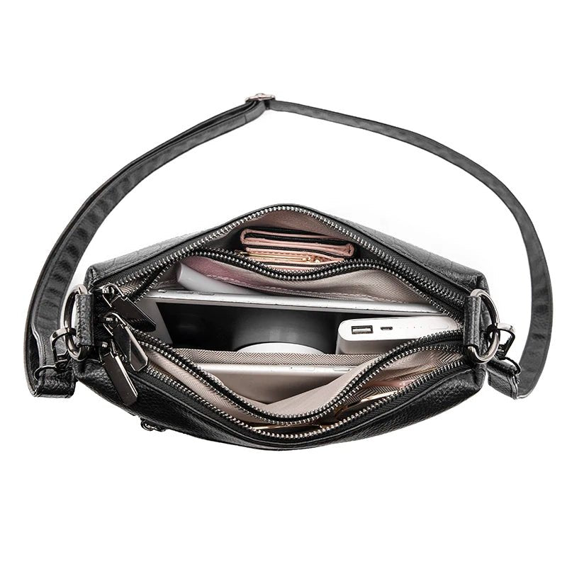 Vue intérieure remplie du sac bandoulière cuir noir croco avec accessoires