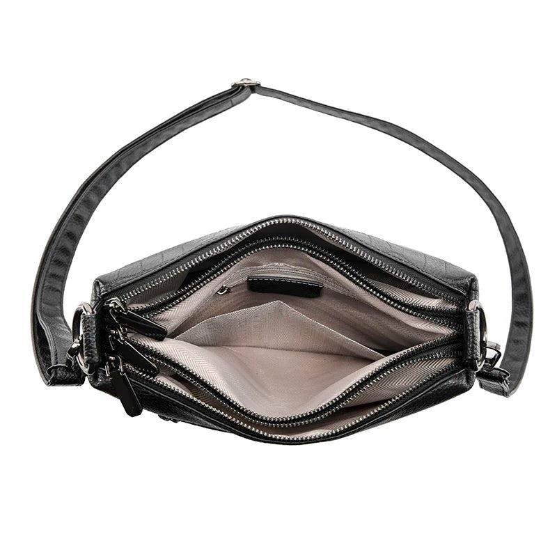 Vue intérieure vide du sac bandoulière cuir noir croco avec poches