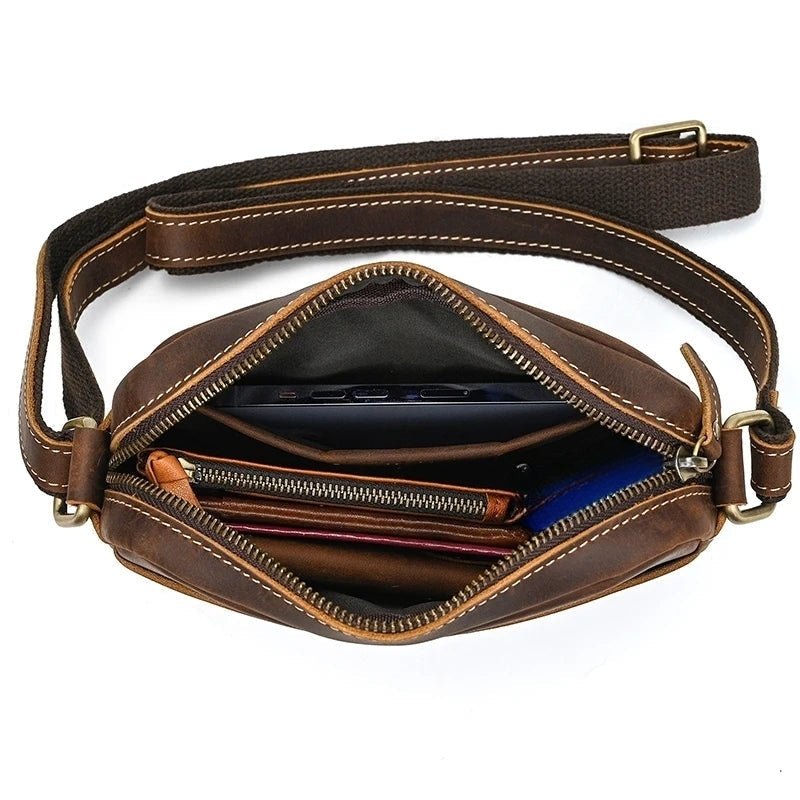 Sac bandoulière en cuir de vachette marron rempli avec cahiers et objets