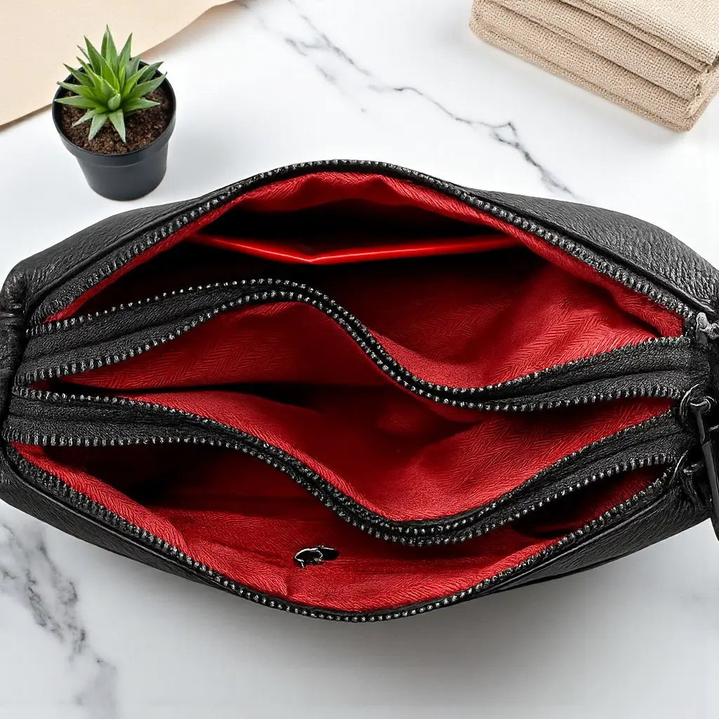 Intérieur du sac bandoulière femme en cuir noir avec poche zippée