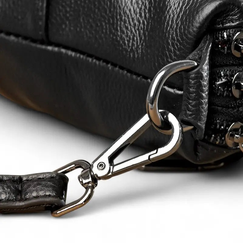 Détail du mousqueton métallique du sac bandoulière femme en cuir noir