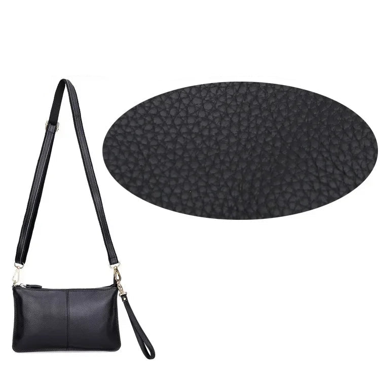 Gros plan sur la texture grainée d’un sac à bandoulière pour femme en cuir noir véritable, bandoulière en toile avec sangle cuir cousue.
