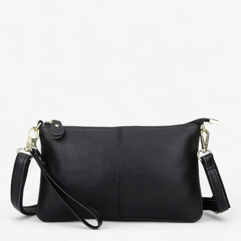 Sac à bandoulière pour femme en cuir noir véritable, vue de face avec sangle amovible et détails dorés.