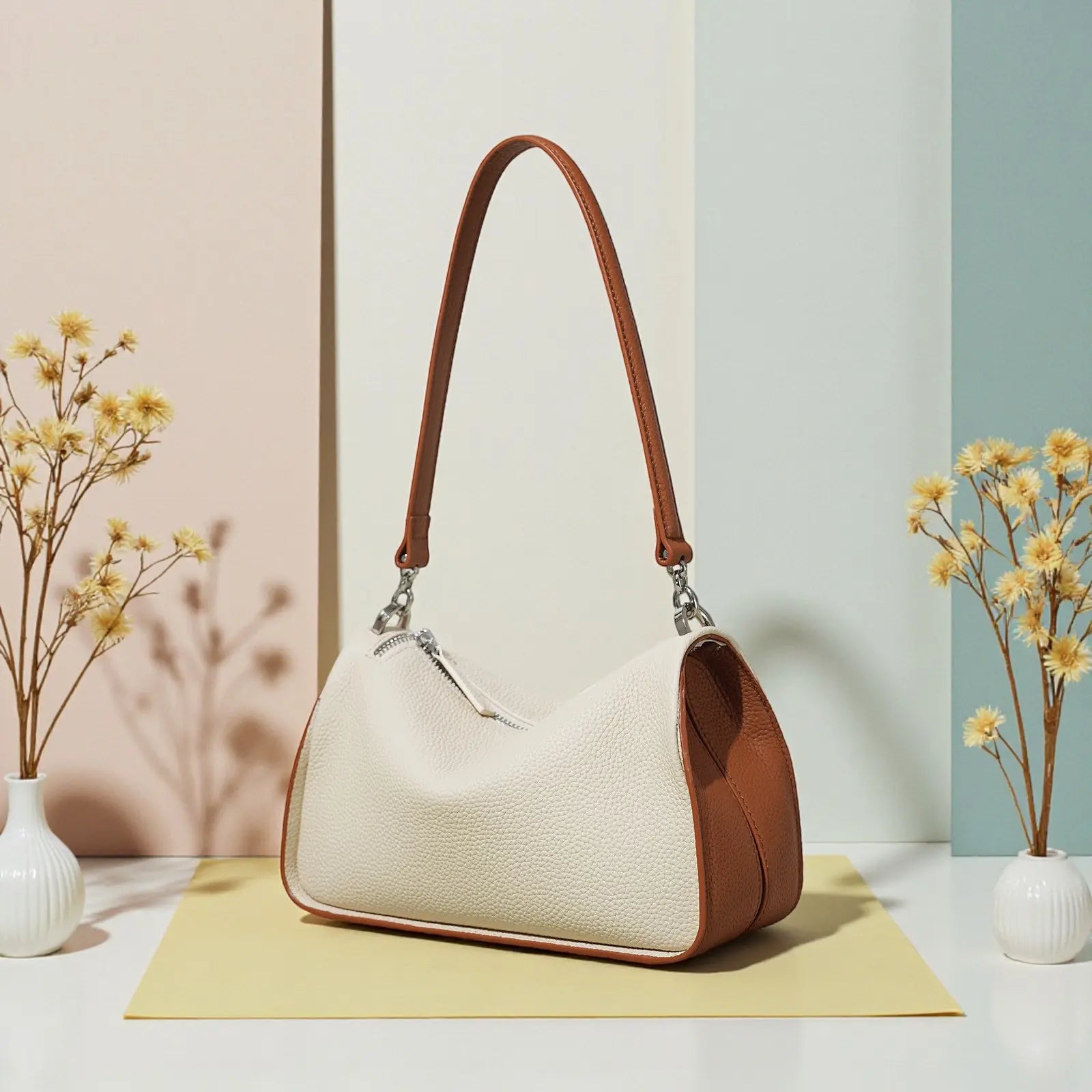 Sac bandoulière femme en cuir de vachette posé sur surface décorative
