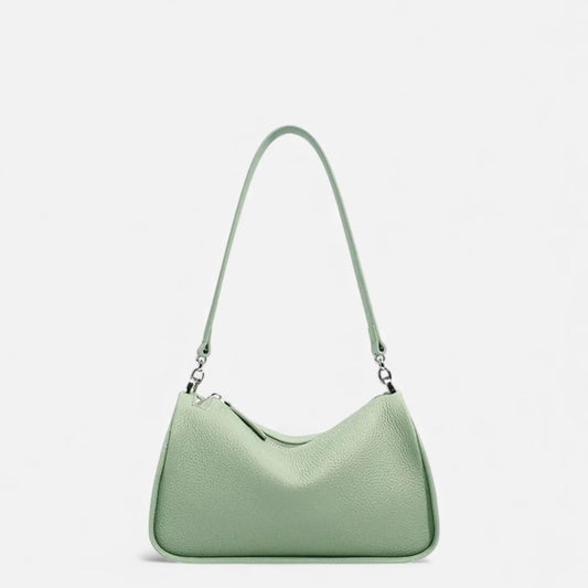 Sac bandoulière femme en cuir de vachette vert porté à l’épaule
