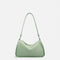 Sac bandoulière femme en cuir de vachette vert porté à l’épaule
