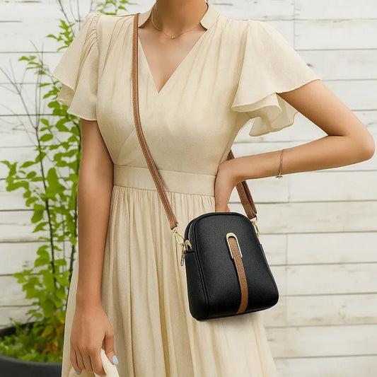 Sac bandoulière femme noir porté à l’épaule, style urbain chic