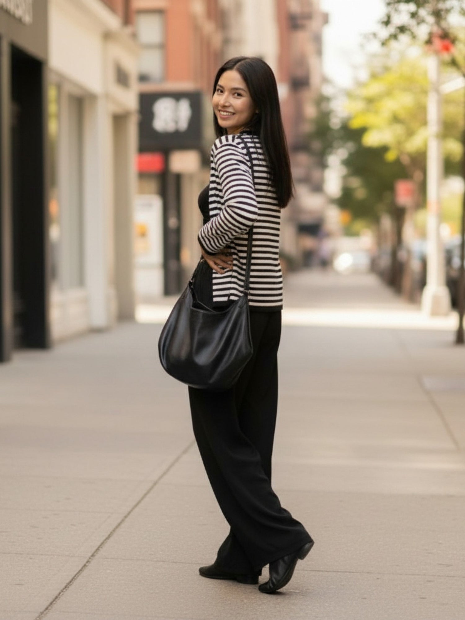 Sac bandoulière femme noir porté à l’épaule en situation quotidienne