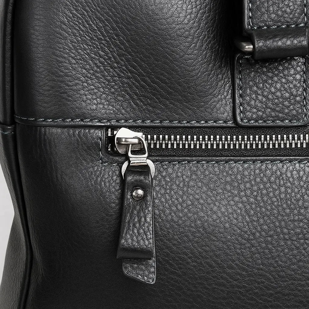 Zoom sur la fermeture zippée latérale du sac à bandoulière homme en cuir grainé noir