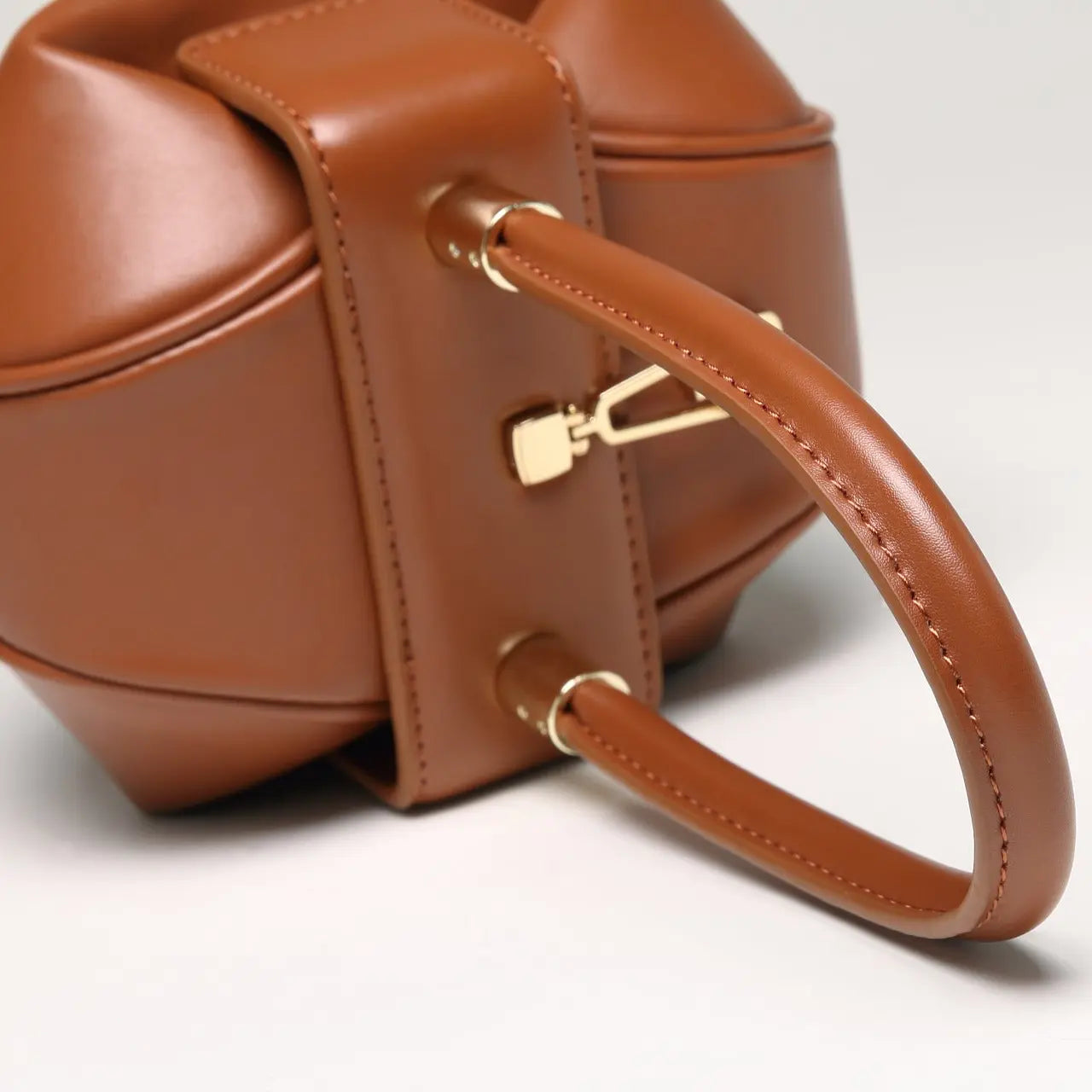 Détail du fermoir doré du sac cabas en cuir bombé marron