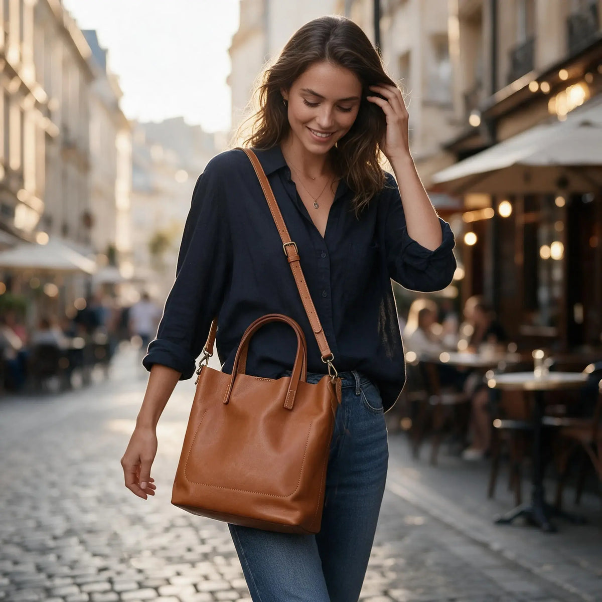 Femme portant un sac cabas en cuir cognac avec anses et bandoulière
