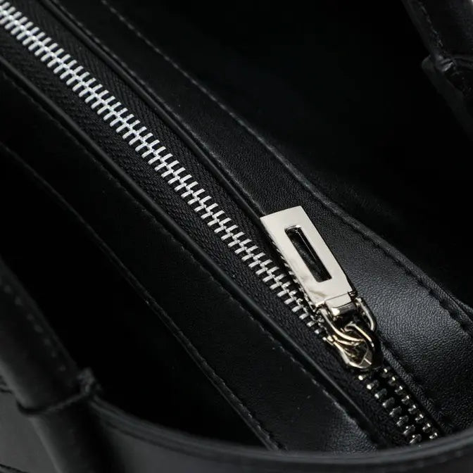 Fermeture éclair métallique du sac cabas en cuir noir
