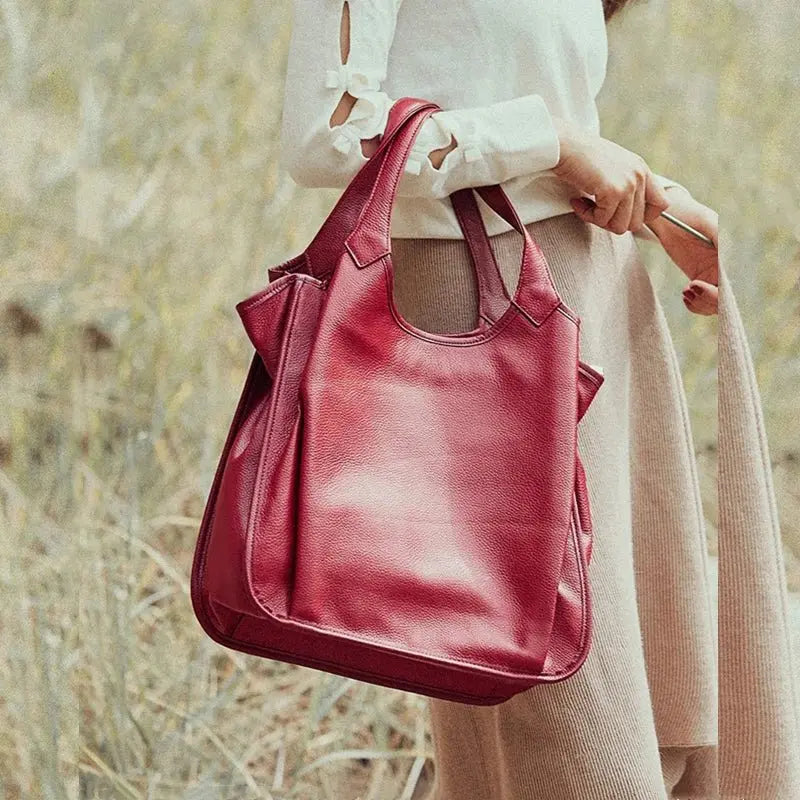 Sac cabas en cuir rouge porté à la main par une femme élégante