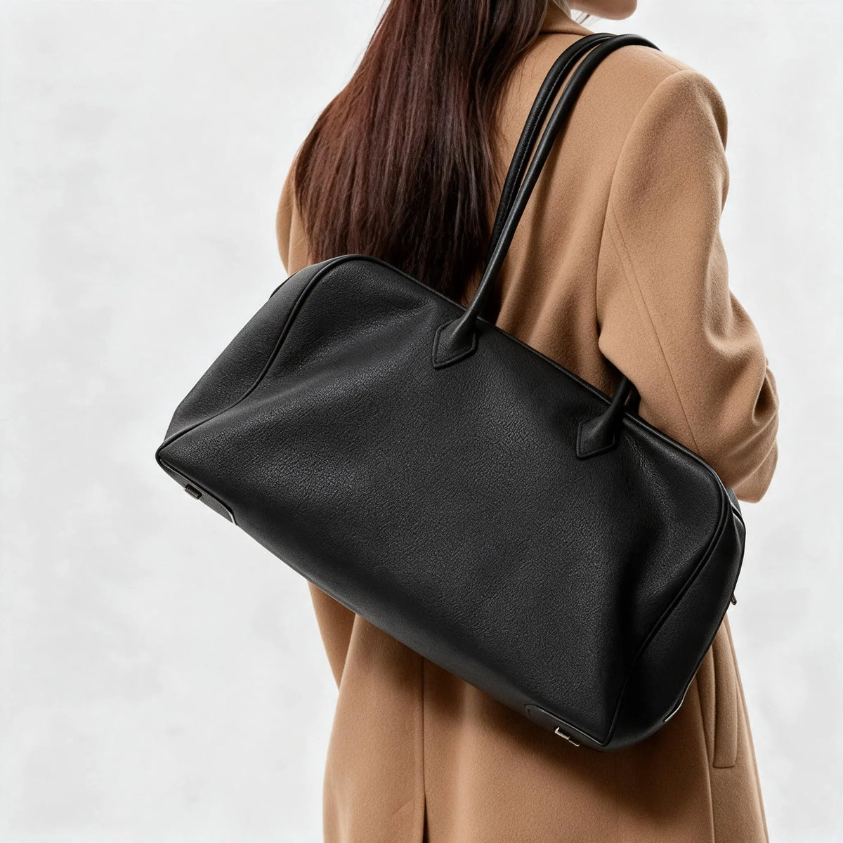 Femme portant un grand sac cabas noir en cuir sur l’épaule, vue de dos