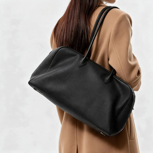 Femme portant un grand sac cabas noir en cuir sur l’épaule, vue de dos