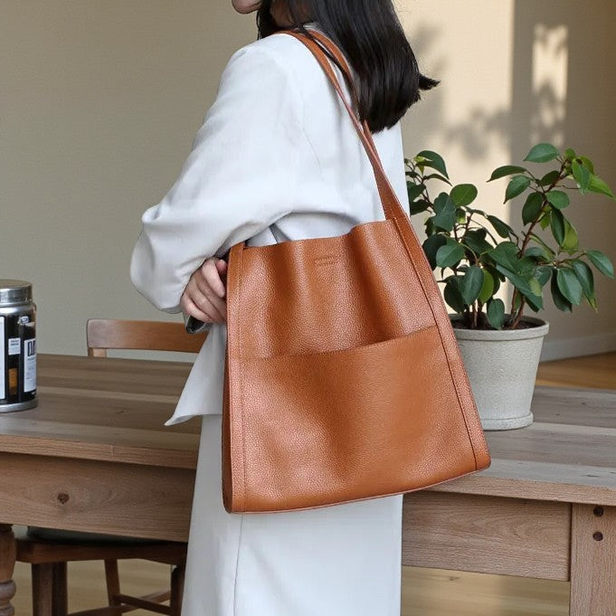 Femme portant un sac cabas en cuir véritable marron clair en intérieur.