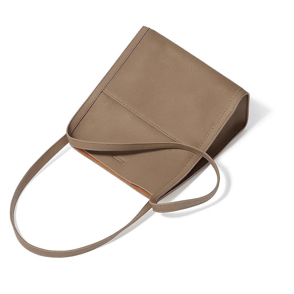 Vue de dessus du sac cabas en cuir véritable marron avec ses anses souples posées à plat.