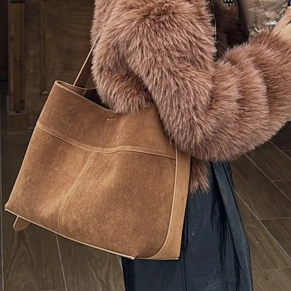 Sac cabas en daim marron clair porté avec un manteau en hiver