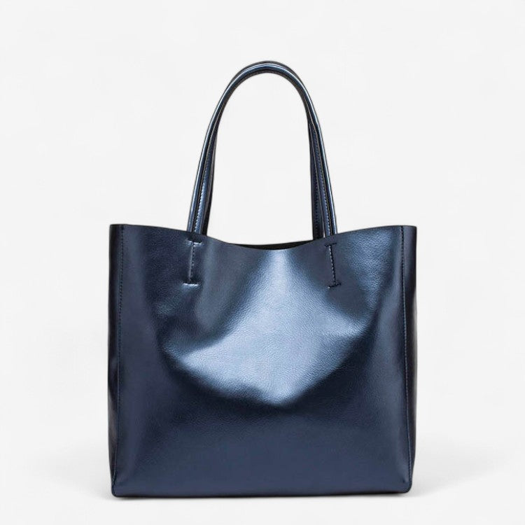 Sac cabas femme en cuir bleu brillant avec anses longues, style épuré.