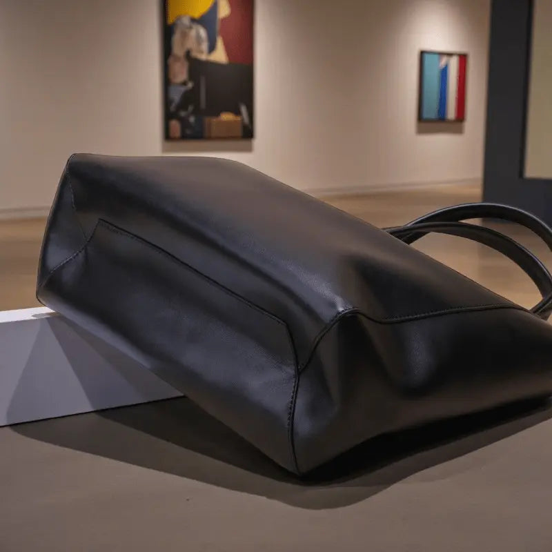 Vue du dessous du sac cabas femme en cuir noir montrant la base renforcée.